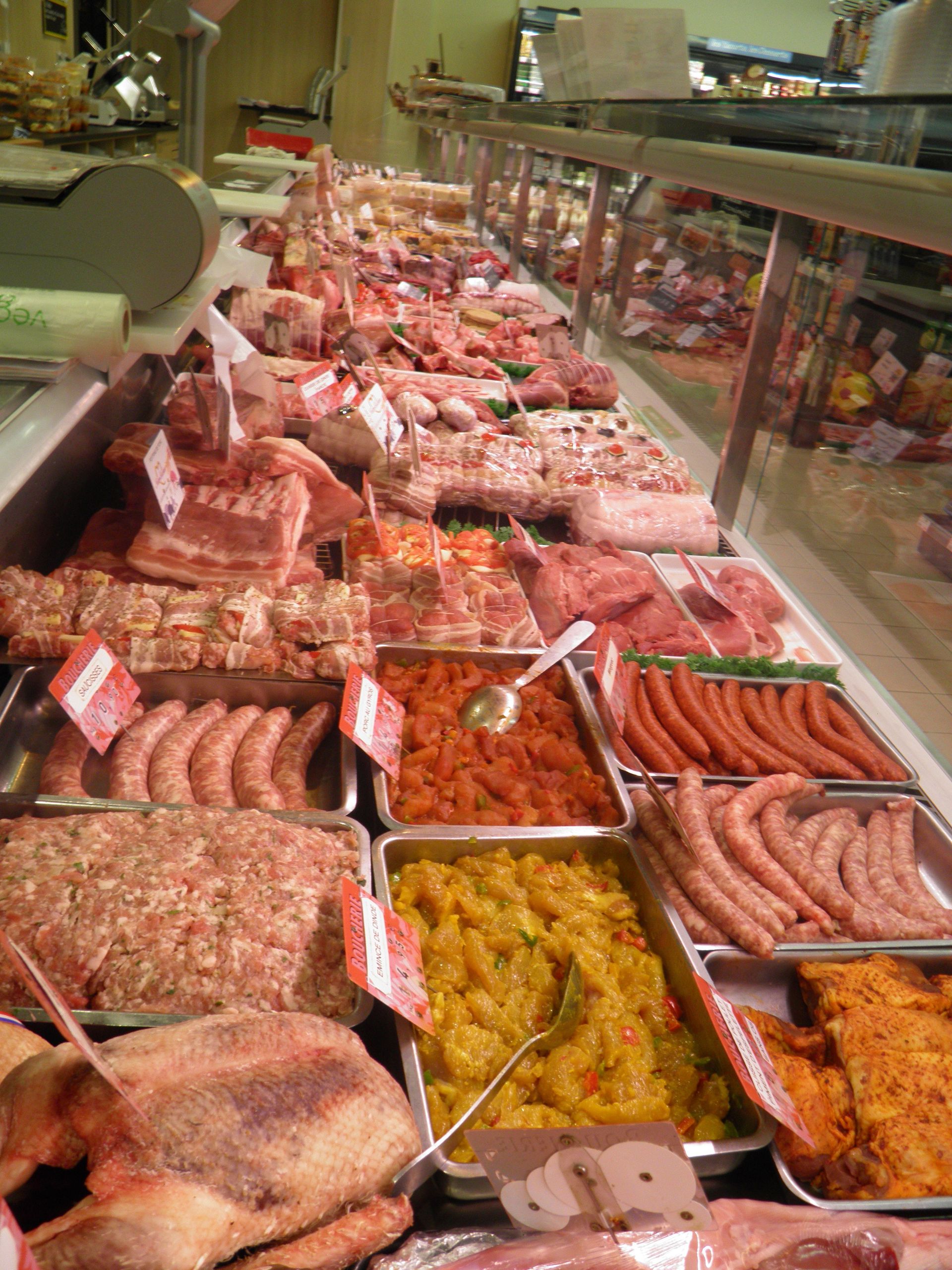 Une vitrine remplie d'une variété de viandes et de légumes.