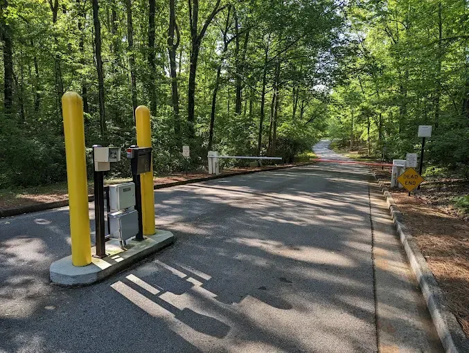 A fence with yellow poles and a mailbox in front of it