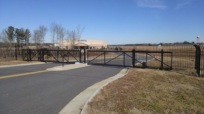 A black fence is along the side of a road.