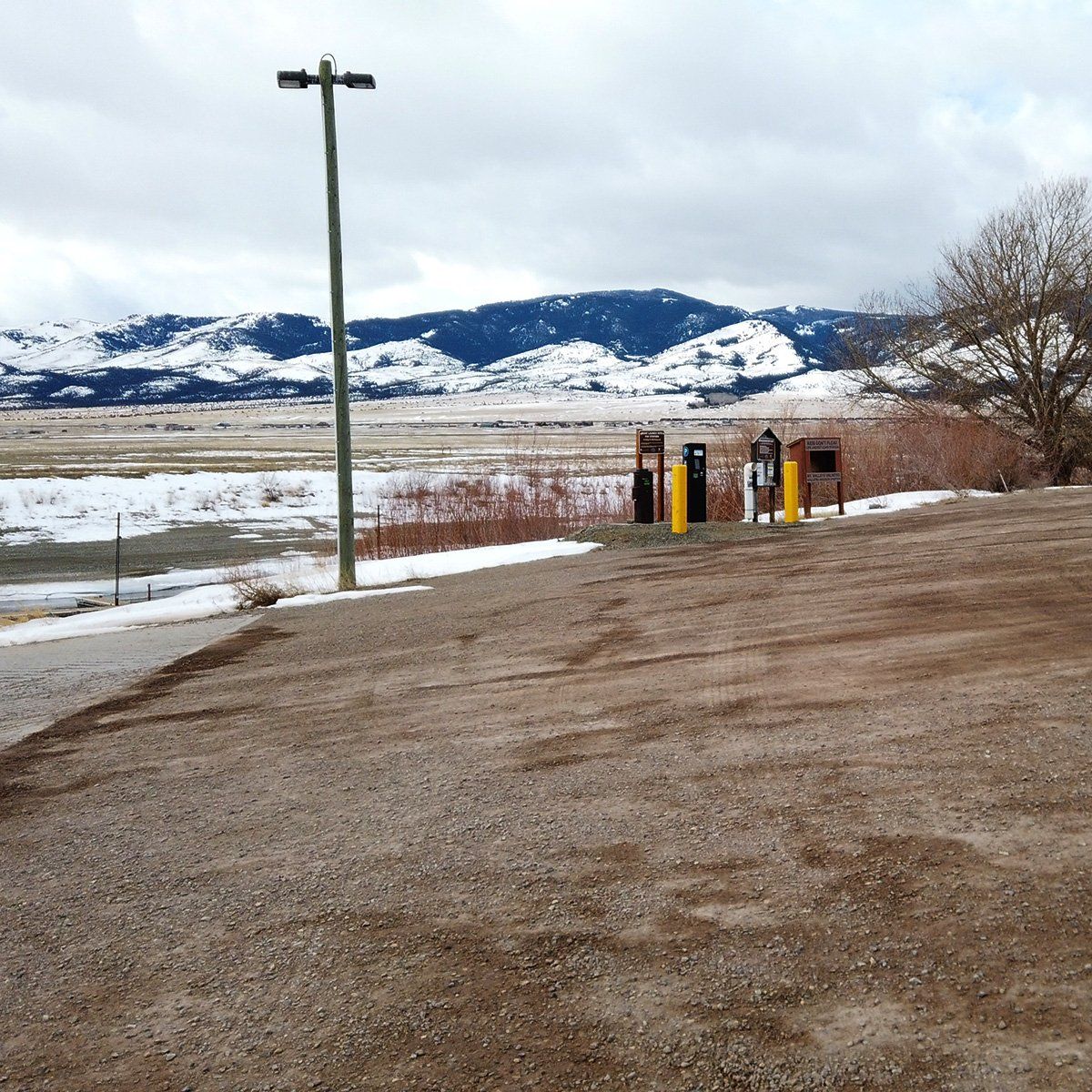 A gravel road with mountains in the background