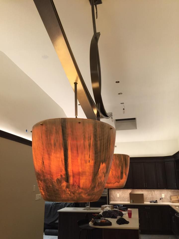 Two pendant lights with textured orange shades hang over a kitchen island.