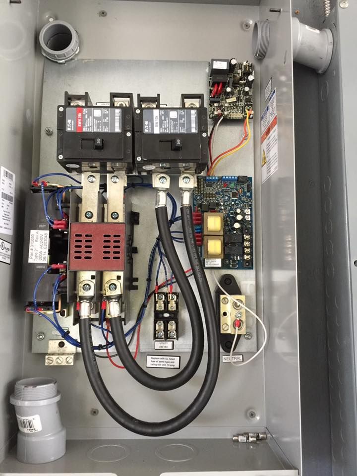 Electrical control panel with circuit breakers and wiring inside a metal box.