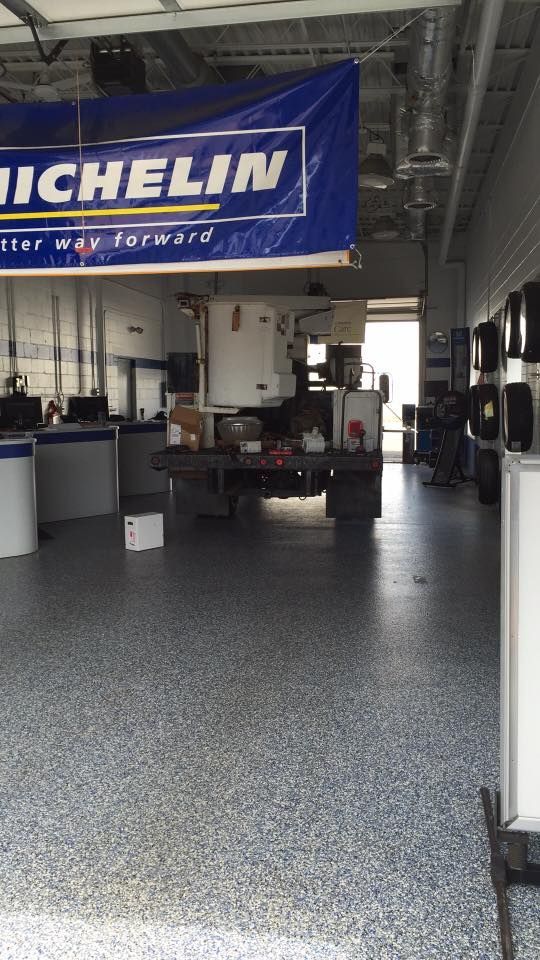 Michelin garage interior with a banner, equipment, and a truck.
