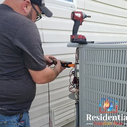 A man is working on an air conditioner outside of a house.