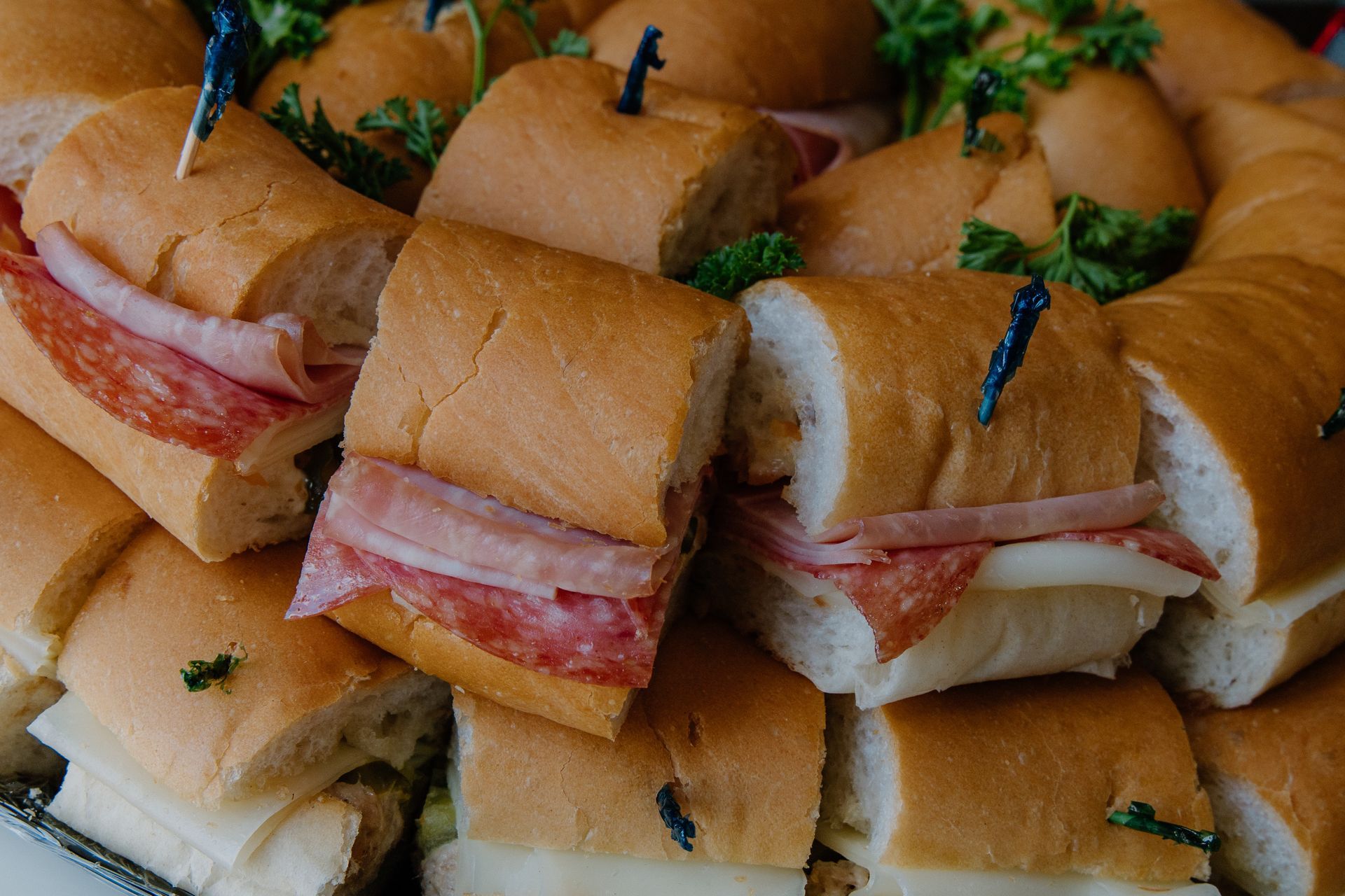 Mini sandwiches with meat and cheese, held together with toothpicks.