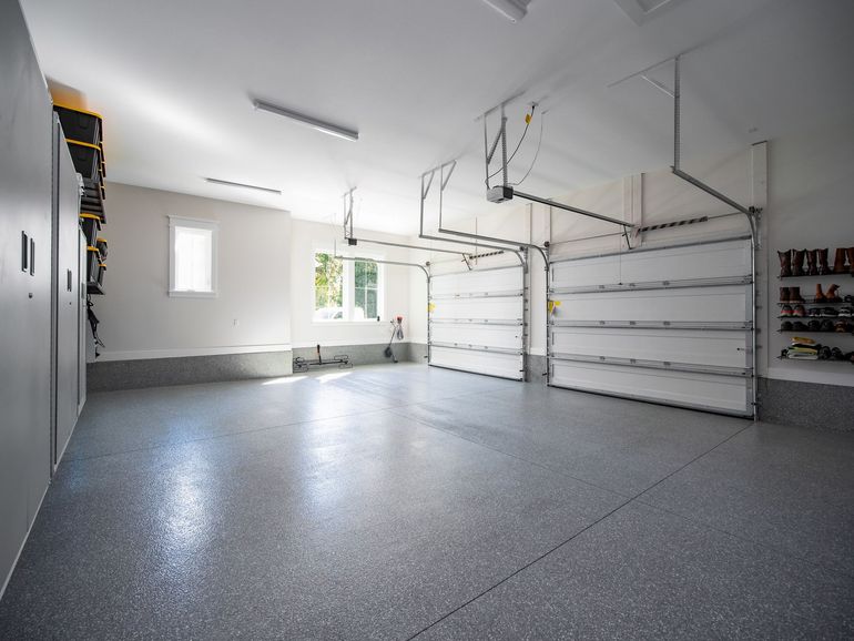 An Empty Garage With a Garage Door Open and a Window