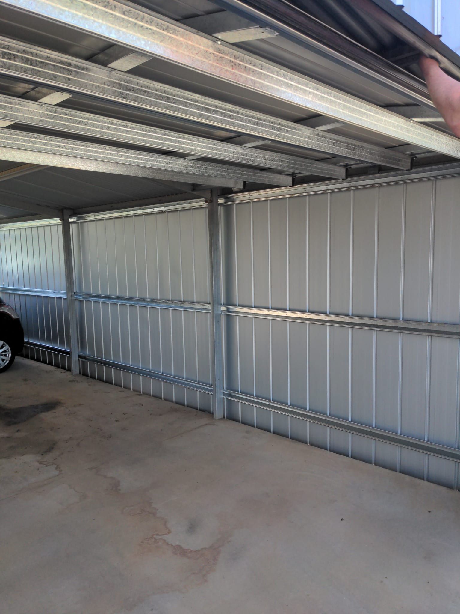 An Empty Warehouse With a Roller Door and a Door — Goldfields Garage Doors & Gates in Wendouree, VIC