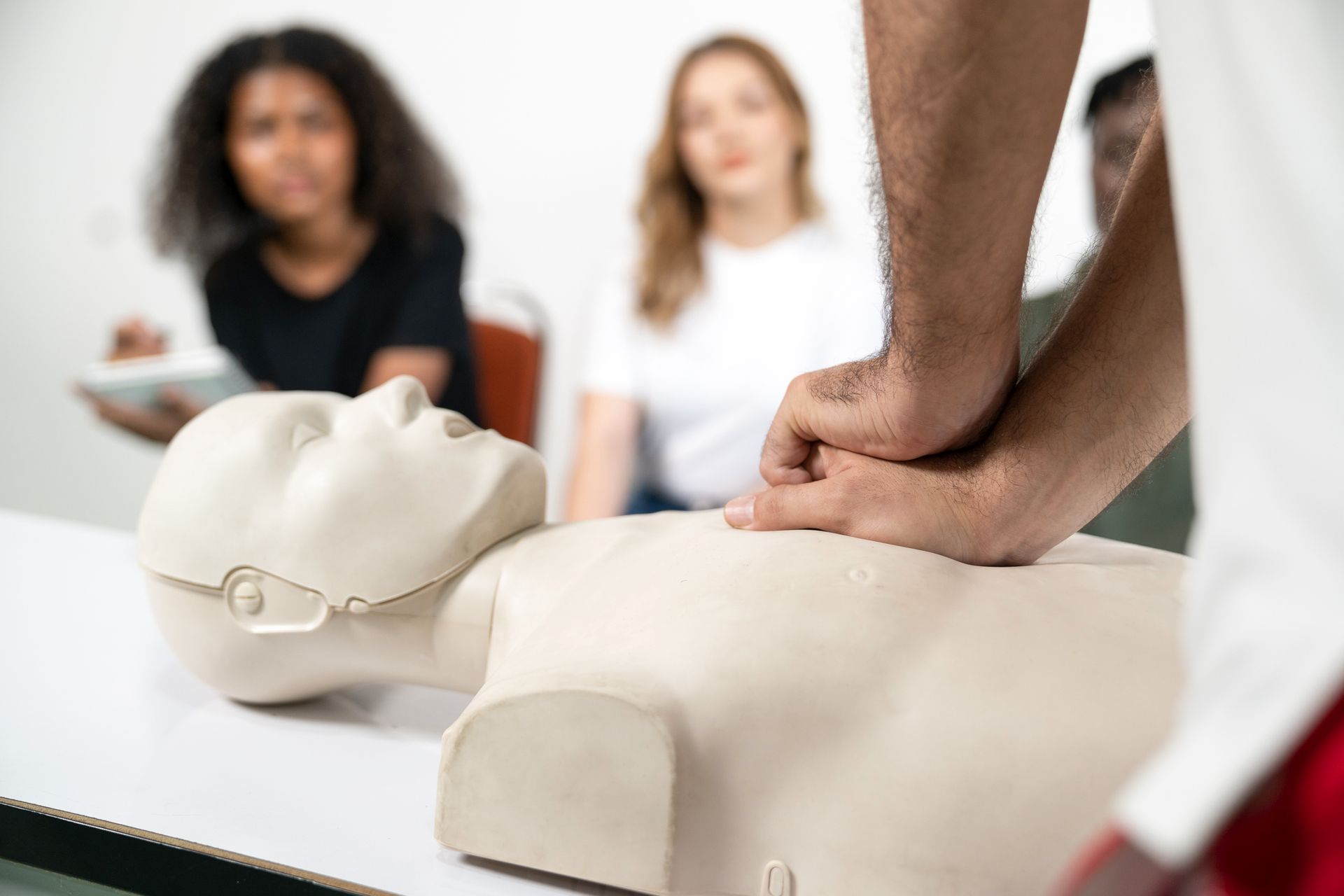 A man is doing a resuscitation on a mannequin.
