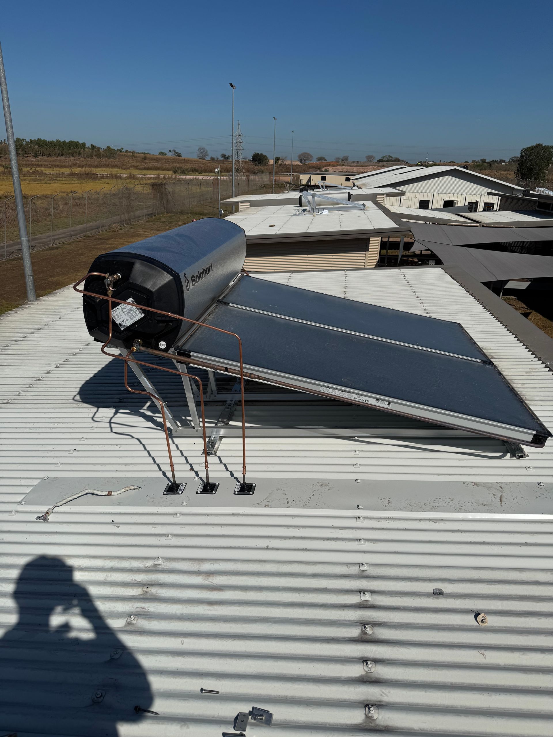Solar water heater on a corrugated metal roof, outdoors on a sunny day. — Darwin Plumbing Maintenance in Knuckey Lagoon, NT