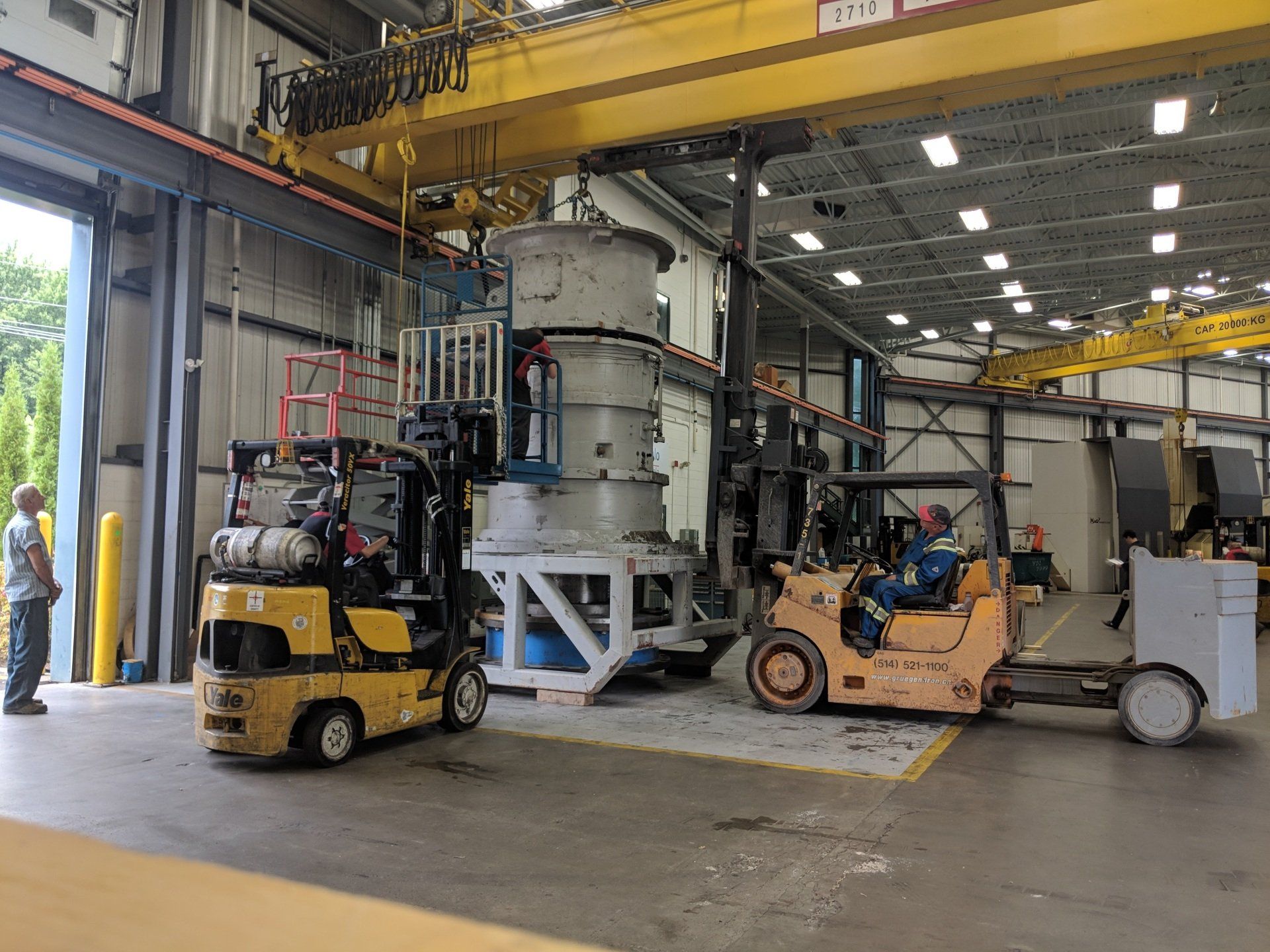 Deux chariots élévateurs sont garés dans un entrepôt l'un à côté de l'autre.