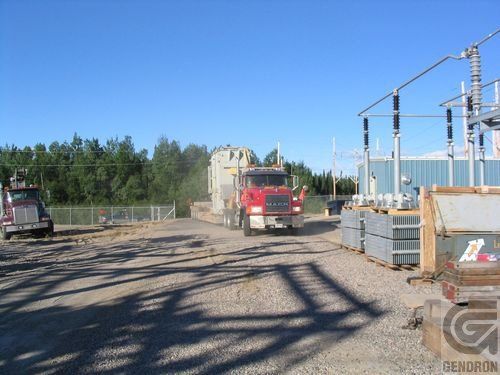 A mack truck is driving down a gravel road