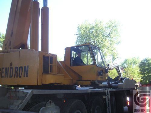 Une grue Bendron jaune est garée sur le bord de la route
