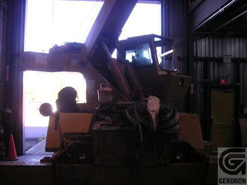 Un tracteur est garé dans un garage avec un panneau indiquant Genoron