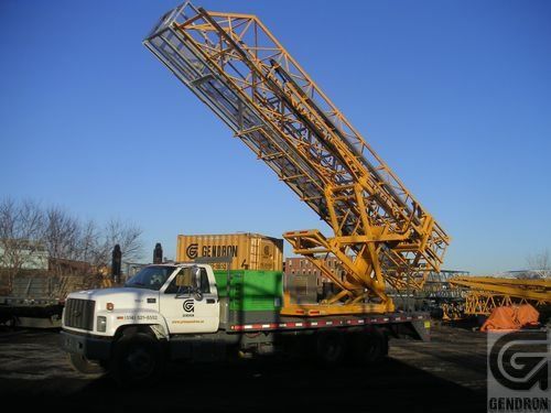 Un camion Genron est garé à côté d'un conteneur jaune