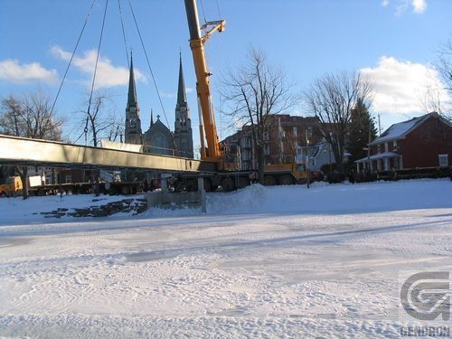Une grande grue lève un pont dans la neige