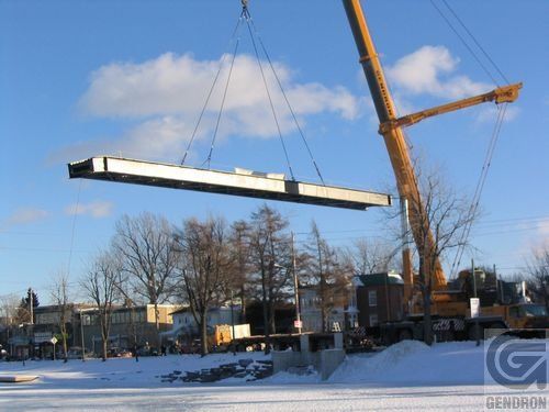 Une grande grue soulève un gros morceau de métal