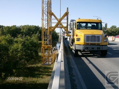 Un camion jaune est garé sur le bord d’une autoroute