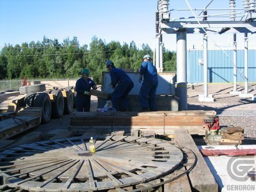 A group of men are working on a large wooden wheel with the word genoron on the bottom