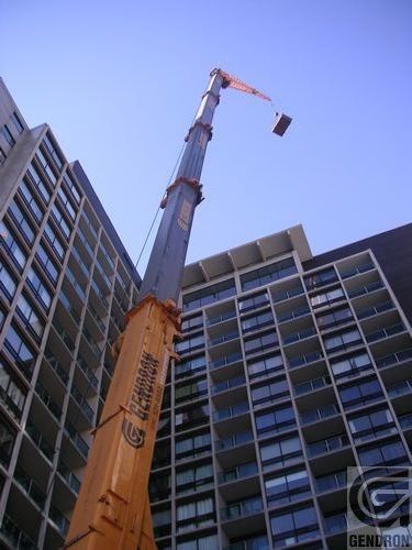 Une grande grue se trouve devant un grand bâtiment