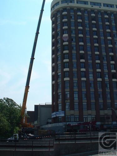 Un grand bâtiment en brique avec une grue devant lui