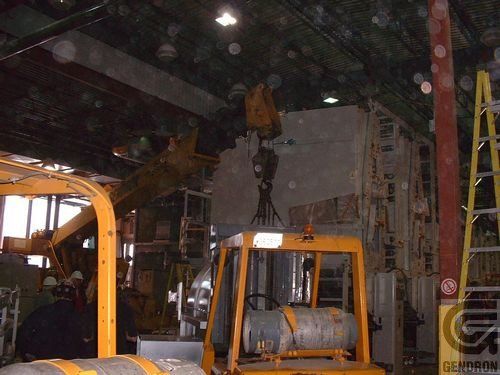 A yellow forklift is in a warehouse with a sign that says gs