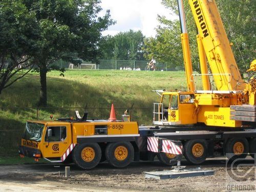 Une grue Norton jaune est garée sur un chemin de terre