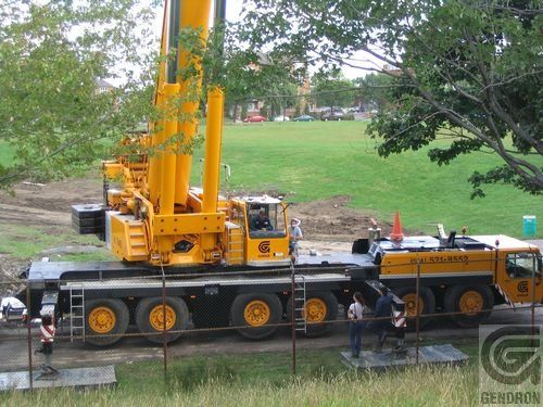 Une grande grue jaune est garée sur le bord de la route