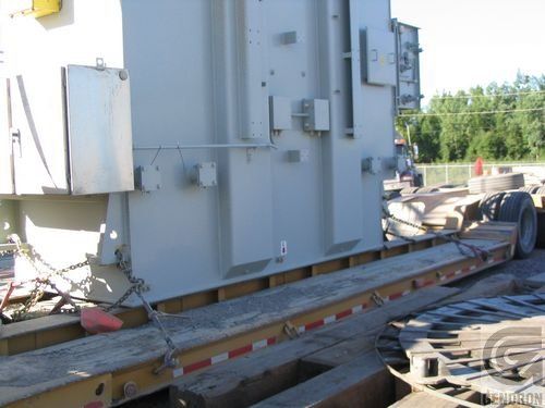 A large gray transformer is sitting on top of a trailer