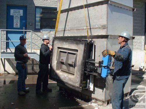 A group of men are working on a large piece of metal