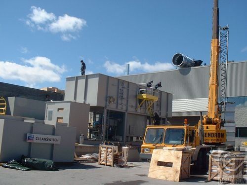 A large yellow crane is sitting in front of a building