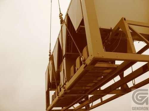 Un grand conteneur est soulevé par une grue et les lettres g sont visibles en bas