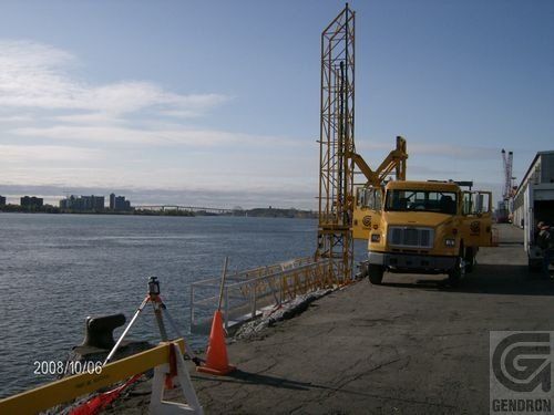 Un camion jaune est garé à côté d’un plan d’eau