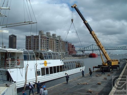 Un bateau est soulevé par une grue avec le mot Genoron en bas