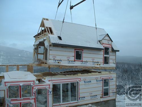 Une grue soulève une maison recouverte de polystyrène