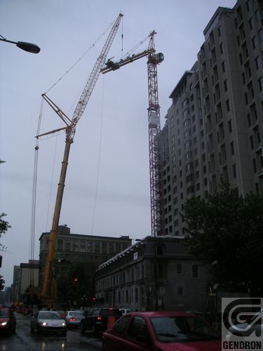 Une voiture rouge est garée devant un immeuble qui dit Gendron
