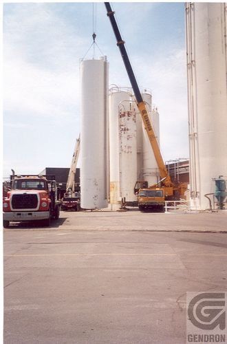 Un camion est garé devant un immeuble avec une grue en arrière-plan