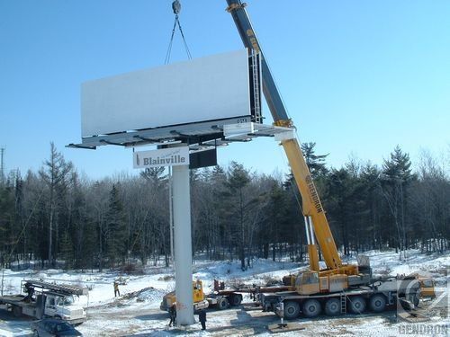 Une grue soulève un panneau publicitaire indiquant Nashville
