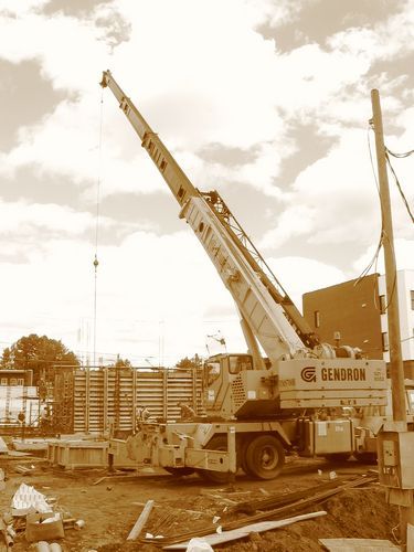 Une photo sépia d'une grue sur un chantier de construction