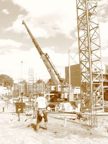 Une photo en noir et blanc d’un chantier de construction avec une grue en arrière-plan.