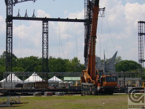Une grande grue orange est utilisée pour construire une scène