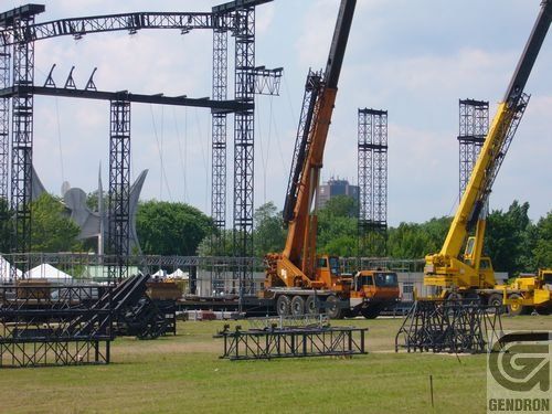 Plusieurs camions et grues se trouvent dans un champ avec les lettres g en bas