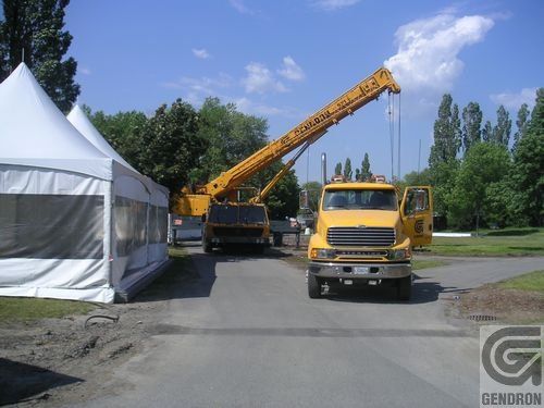 Un camion jaune est garé devant une tente blanche