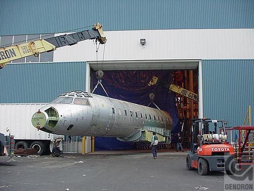 Un avion est transporté dans un hangar par un chariot élévateur Toyota