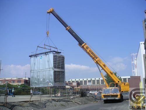 Une grande grue jaune soulève un grand conteneur