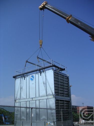 Une grande structure métallique est soulevée par une grue.