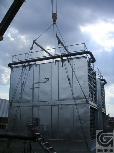 Une grande structure métallique est soulevée par une grue.