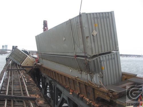 Deux conteneurs maritimes sont empilés l’un sur l’autre sur une voie ferrée.