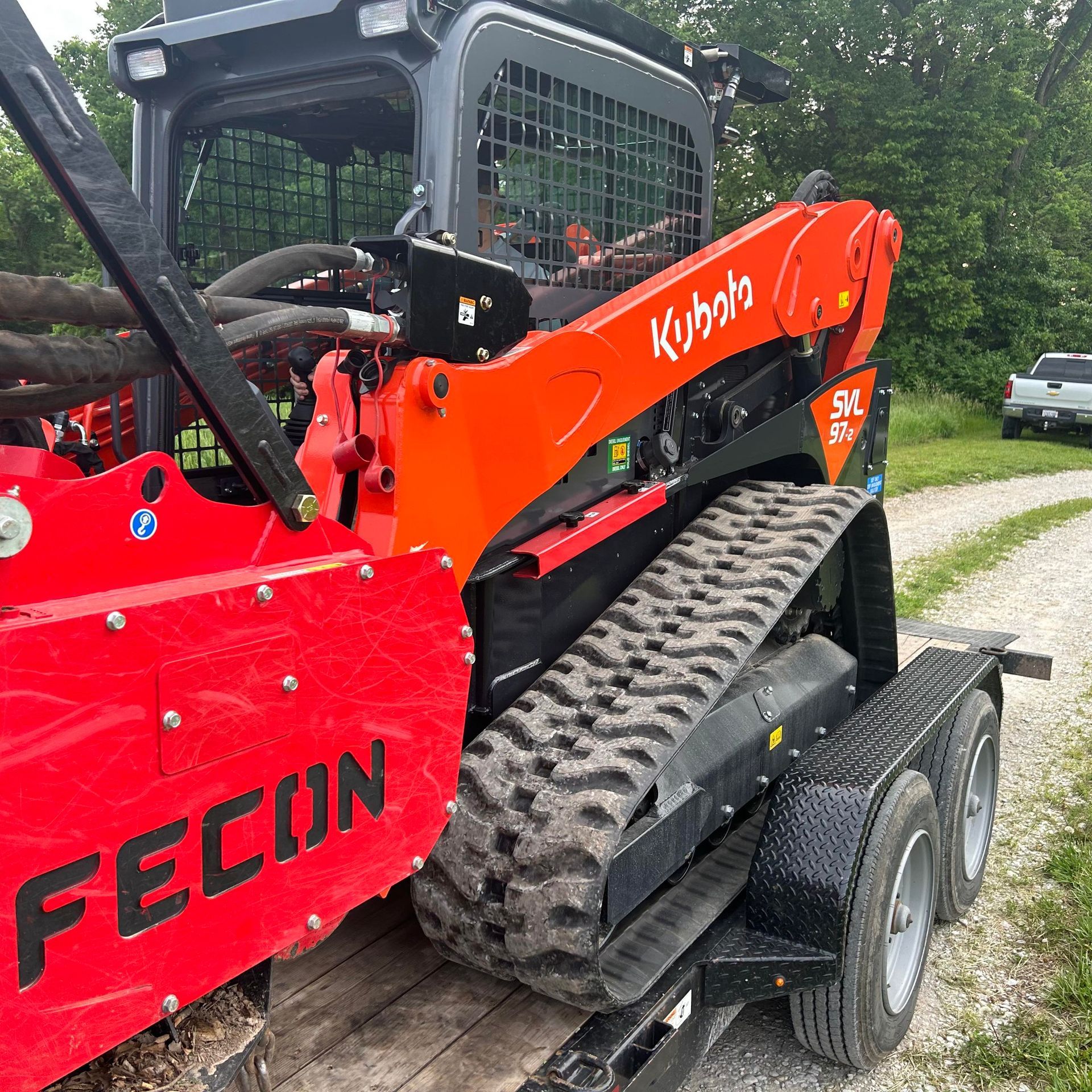 A red kubota skid steer is on a trailer