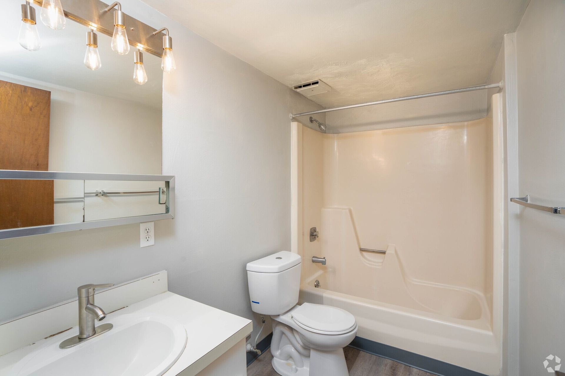 Bathroom with white sink, toilet, and shower/tub. Gray walls and flooring.