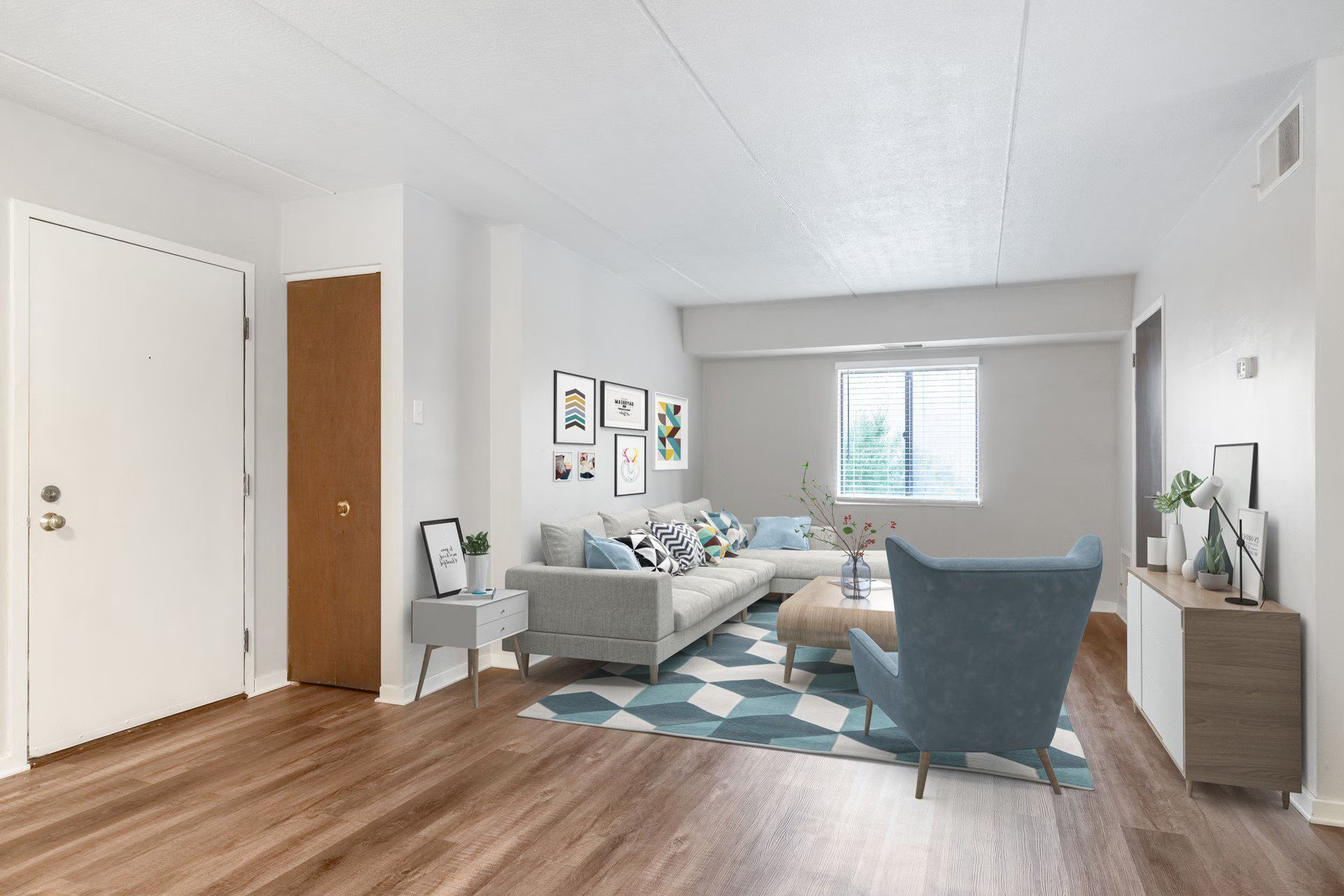 Living room with hardwood floors, white walls, and blue furniture.